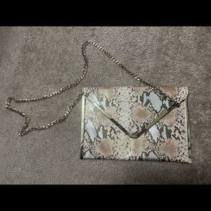 Bebe Large envelope style snakeskin print purse with gold chain. Minimal use